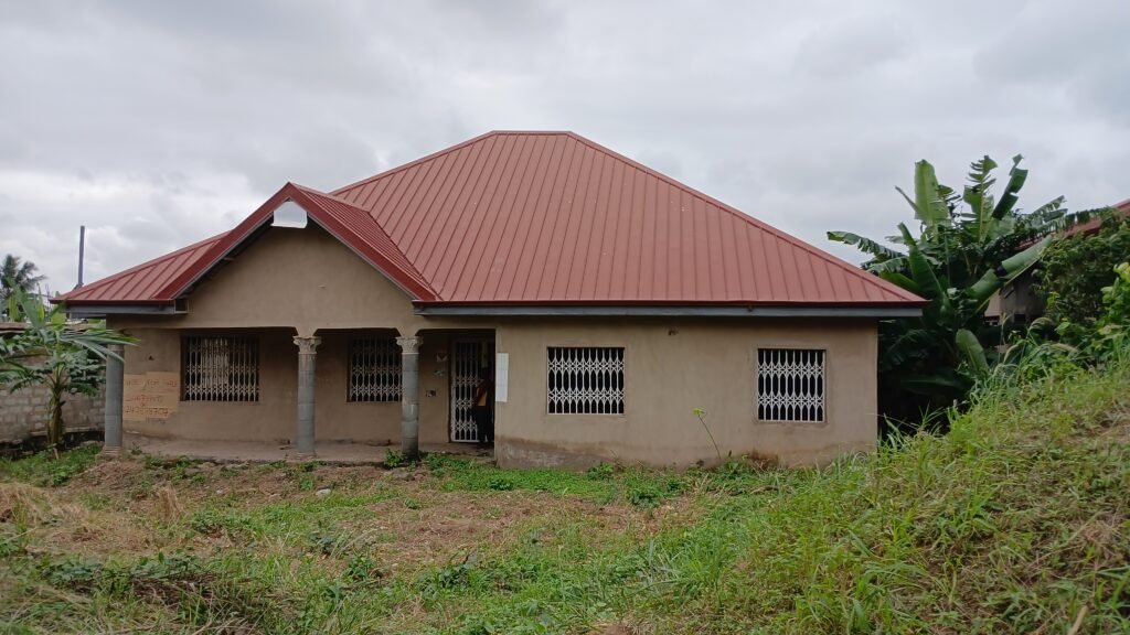 3-bedroom house with a red metal roof, unpainted plaster walls, and secure window grills.
